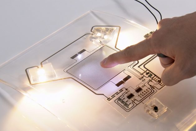 IMPC技術の導入例。曲面状の樹脂にインクジェット印刷で配線したオーバーヘッドコンソール(車内灯)。タッチセンサーに触れるとライトが点灯する